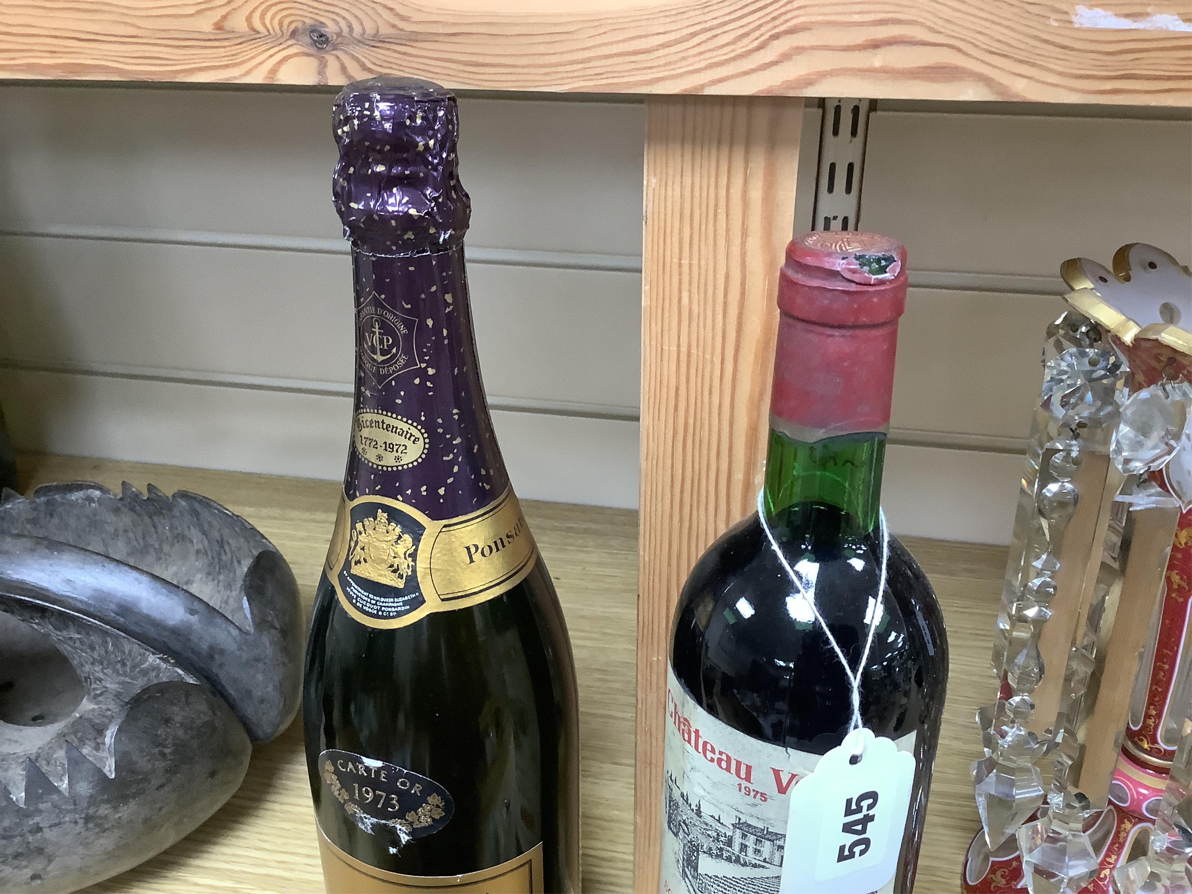 A bottle of 1973 Veuve Clicquot Ponsardin champagne and a bottle of 1975 Chateau Vernon. Condition - fair